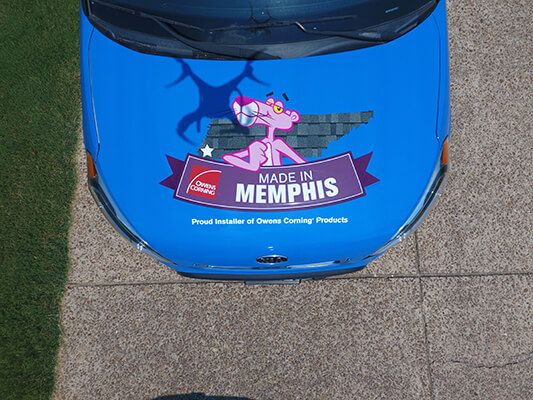 Roofing service car showing Owens Corning logo.